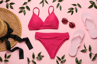 Photo of Stylish bikini and beach accessories on pink background, flat lay