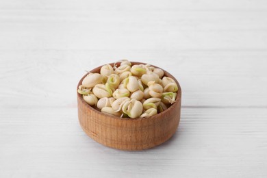 Sprouted kidney beans in bowl on white wooden table, closeup
