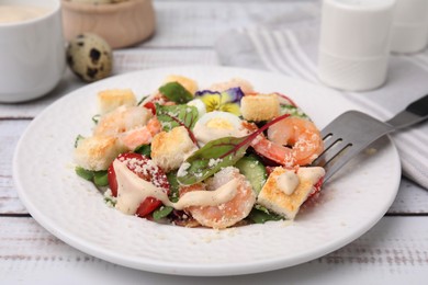 Photo of Delicious Caesar salad with shrimps on white wooden table, closeup