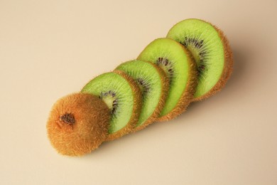 Photo of Sliced fresh kiwi on beige background, above view