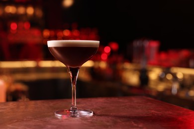 Photo of Glass of delicious Espresso Martini on bar counter, space for text. Alcoholic cocktail
