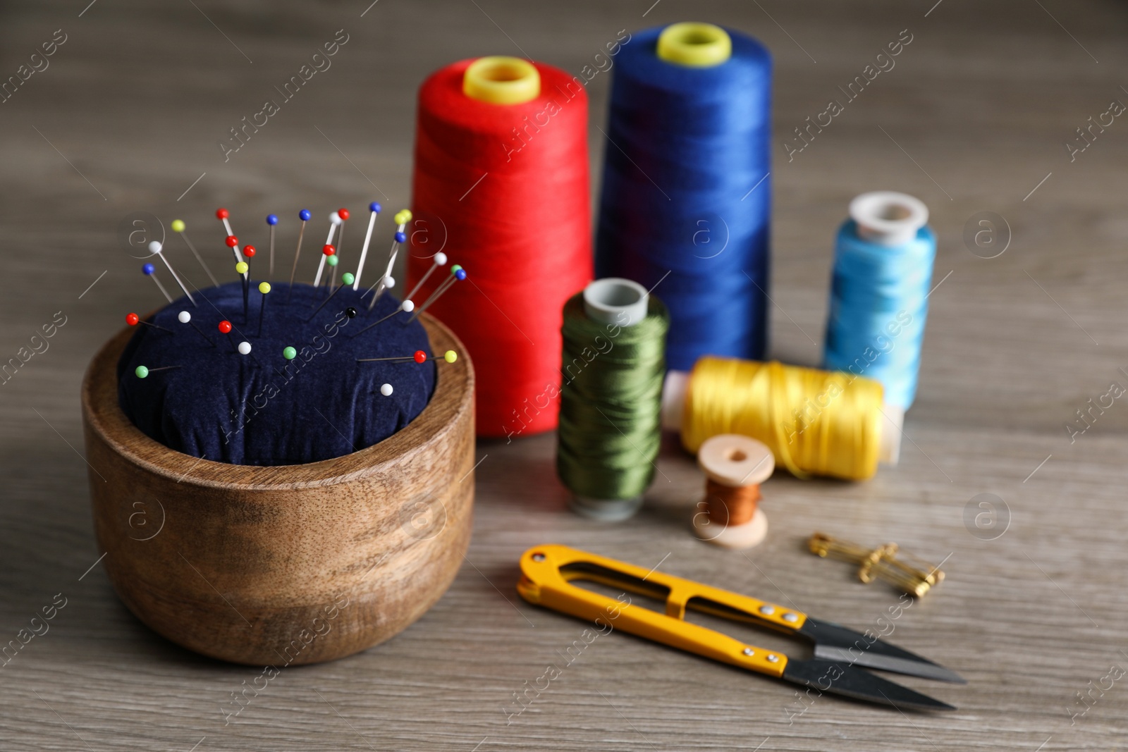 Photo of Set of sewing supplies and accessories on wooden table