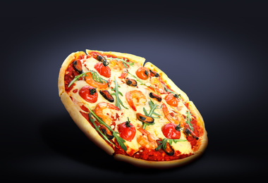 Hot tasty seafood pizza on dark background. Image for menu or poster