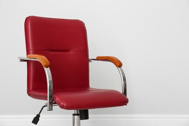 Comfortable office chair near light wall indoors. Space for text