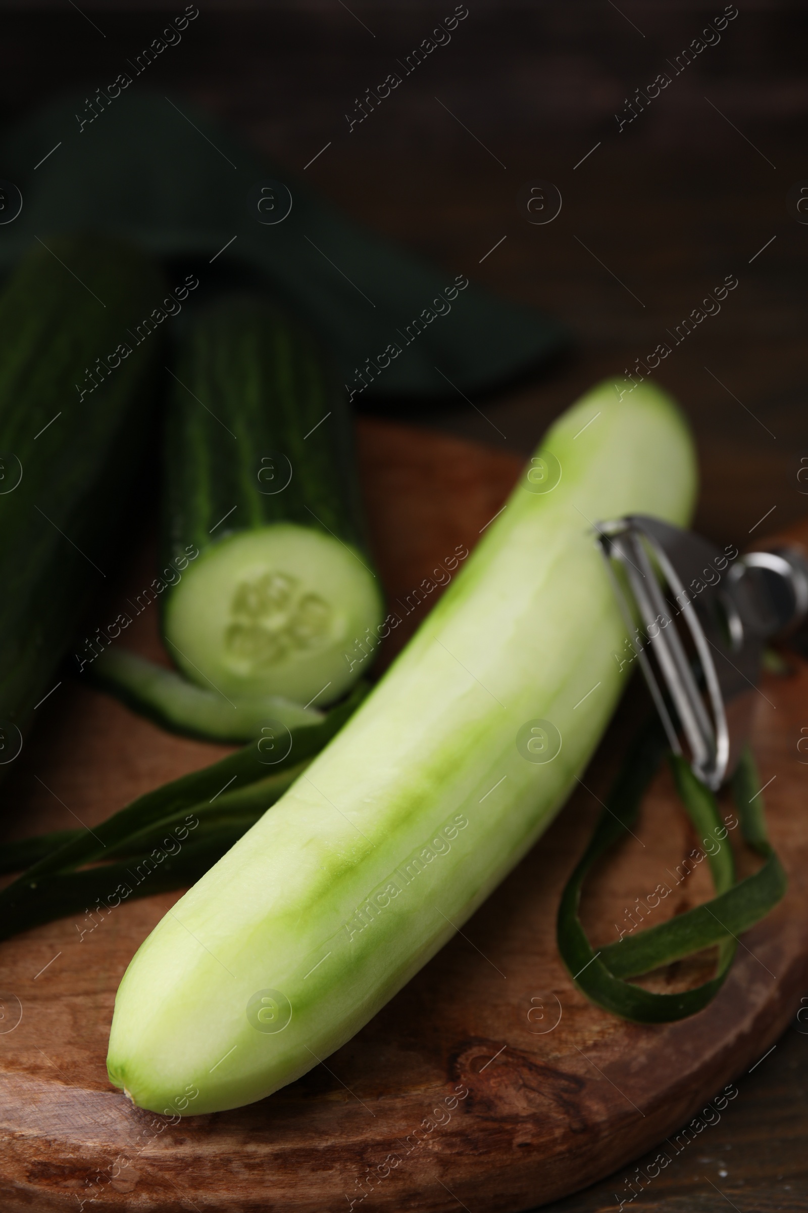 Photo of Fresh peeled and cut cucumbers on wooden table, closeup