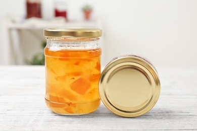 Photo of Two jars with tasty sweet jam on wooden table