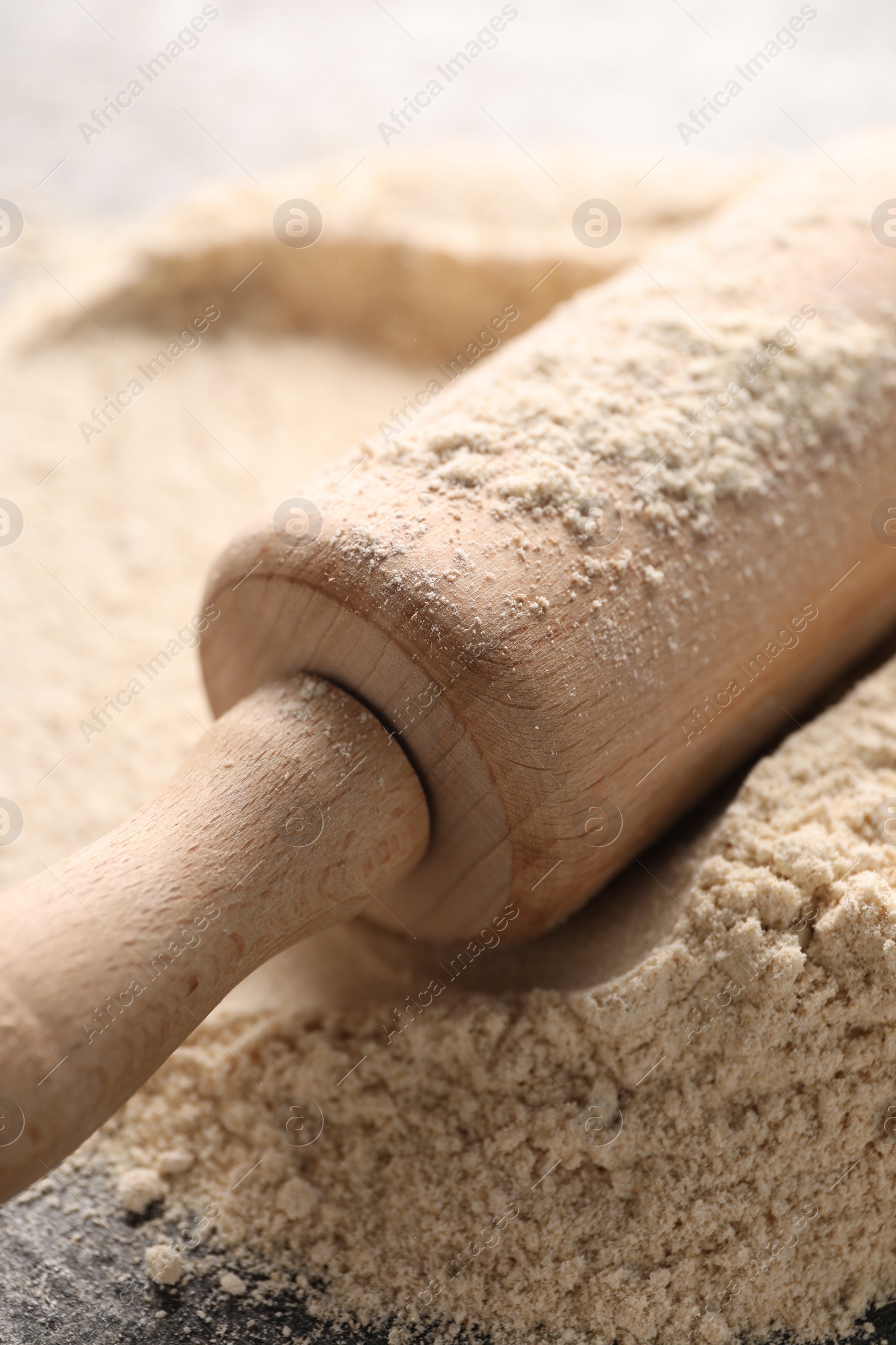 Photo of Rolling pin and flour on table, closeup