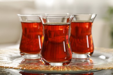 Photo of Glasses with traditional Turkish tea on table indoors, closeup