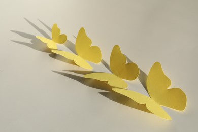 Photo of Yellow paper butterflies on light grey background