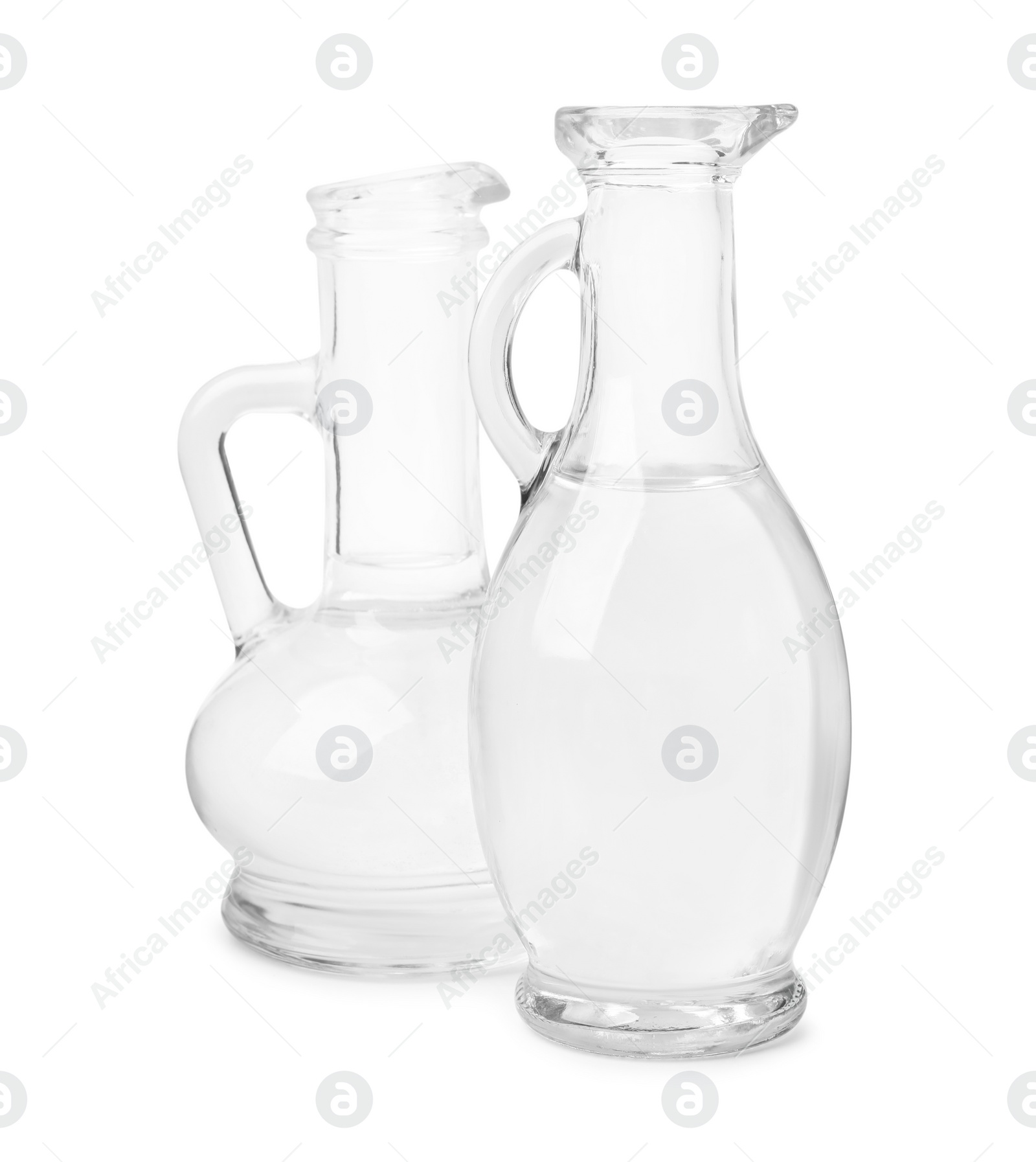 Photo of Vinegar in glass jugs isolated on white