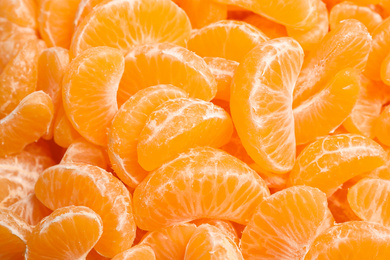 Photo of Fresh juicy tangerine segments as background, closeup