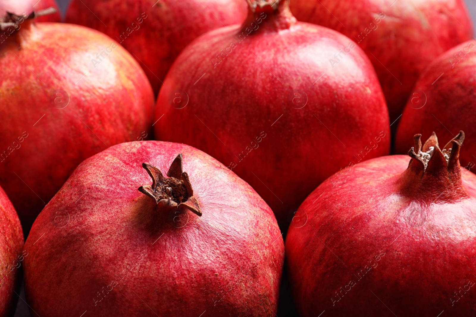 Photo of Many red ripe pomegranate fruits as background, closeup