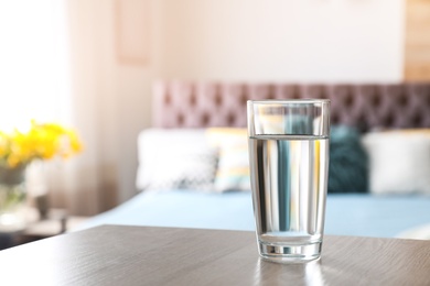 Photo of Glass of fresh water on table indoors. Space for text