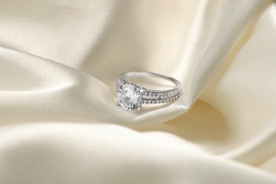 Beautiful ring with gemstones on white fabric. Luxury jewelry