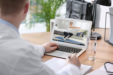 Man watching morning exercise video on laptop at home, closeup