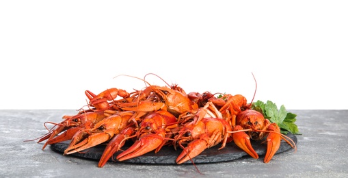Delicious boiled crayfishes on grey table against white background