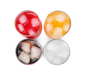 Glasses of different refreshing soda water with ice cubes on white background, top view