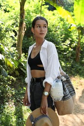 Photo of Beautiful young woman walking in green tropical park
