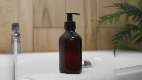 Photo of Bottle of bubble bath on tub indoors