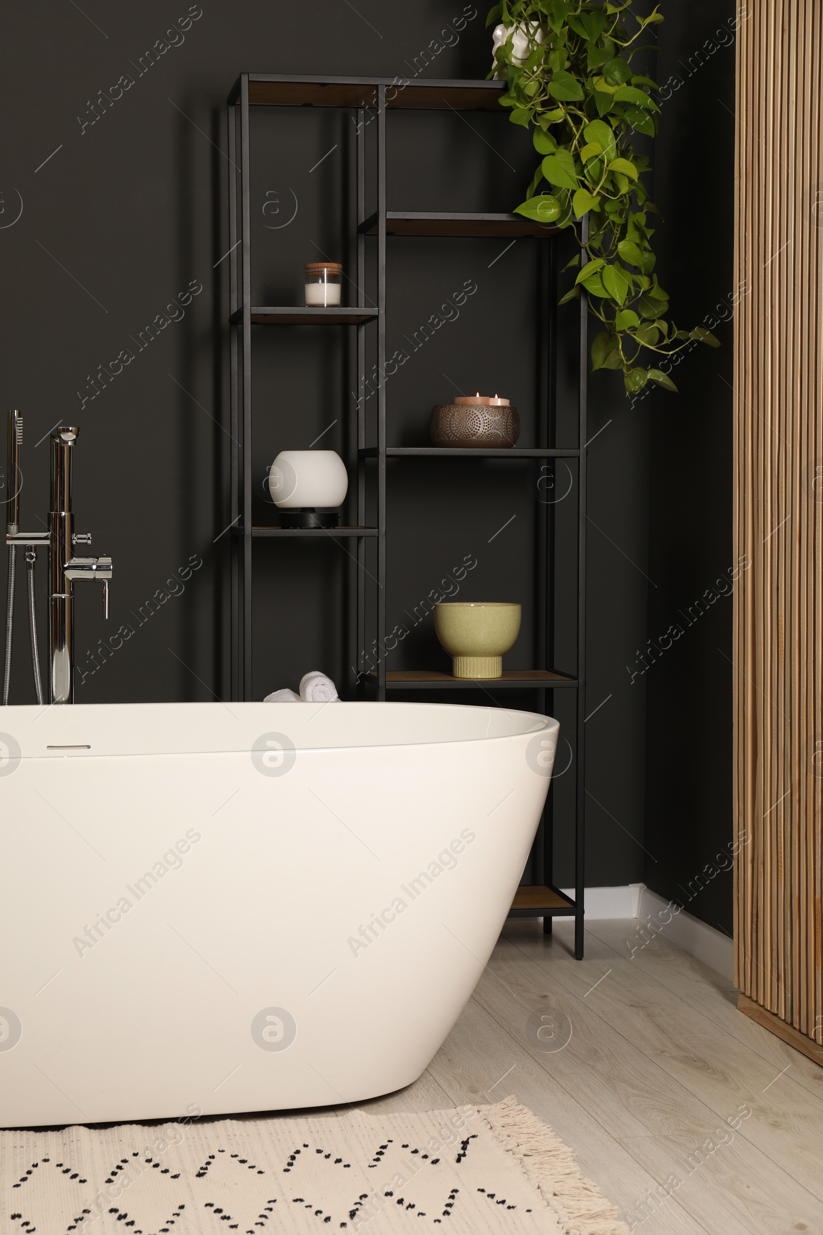 Photo of Spa day. Stylish bathroom with ceramic tub and houseplant