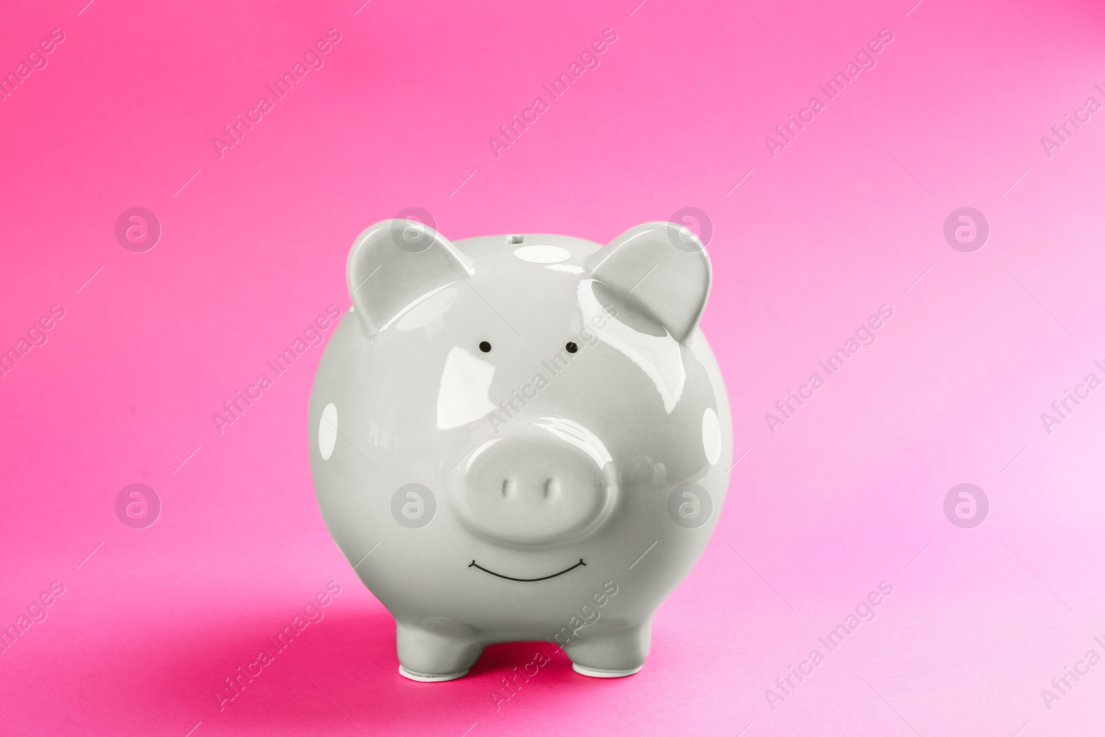 Photo of Cute grey piggy bank on pink background