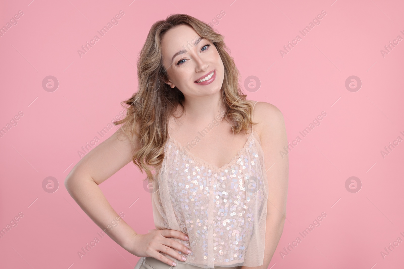 Photo of Portrait of smiling woman on pink background