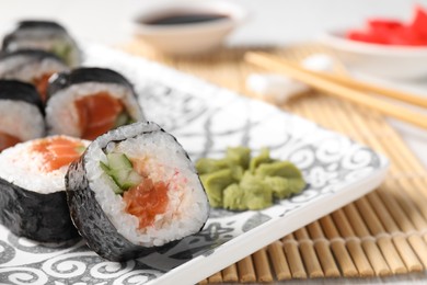 Photo of Tasty sushi rolls with wasabi served on table, closeup. Space for text