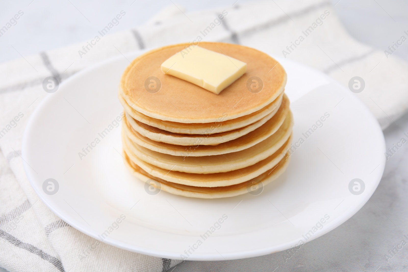 Photo of Delicious pancakes with butter on table, closeup