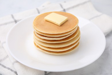 Photo of Delicious pancakes with butter on table, closeup