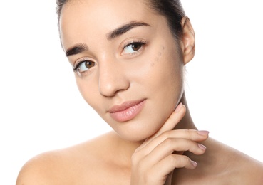 Portrait of young woman with liquid foundation on her face against white background