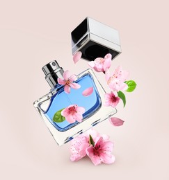 Bottle of perfume and sakura flowers in air on pink beige background