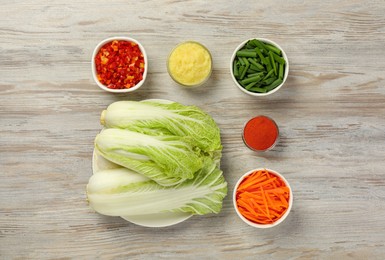 Photo of Fresh Chinese cabbages and other ingredients for kimchi on wooden table, flat lay