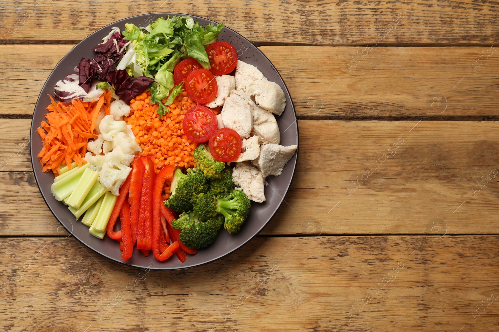 Photo of Balanced diet and healthy foods. Plate with different delicious products on wooden table, top view. Space for text