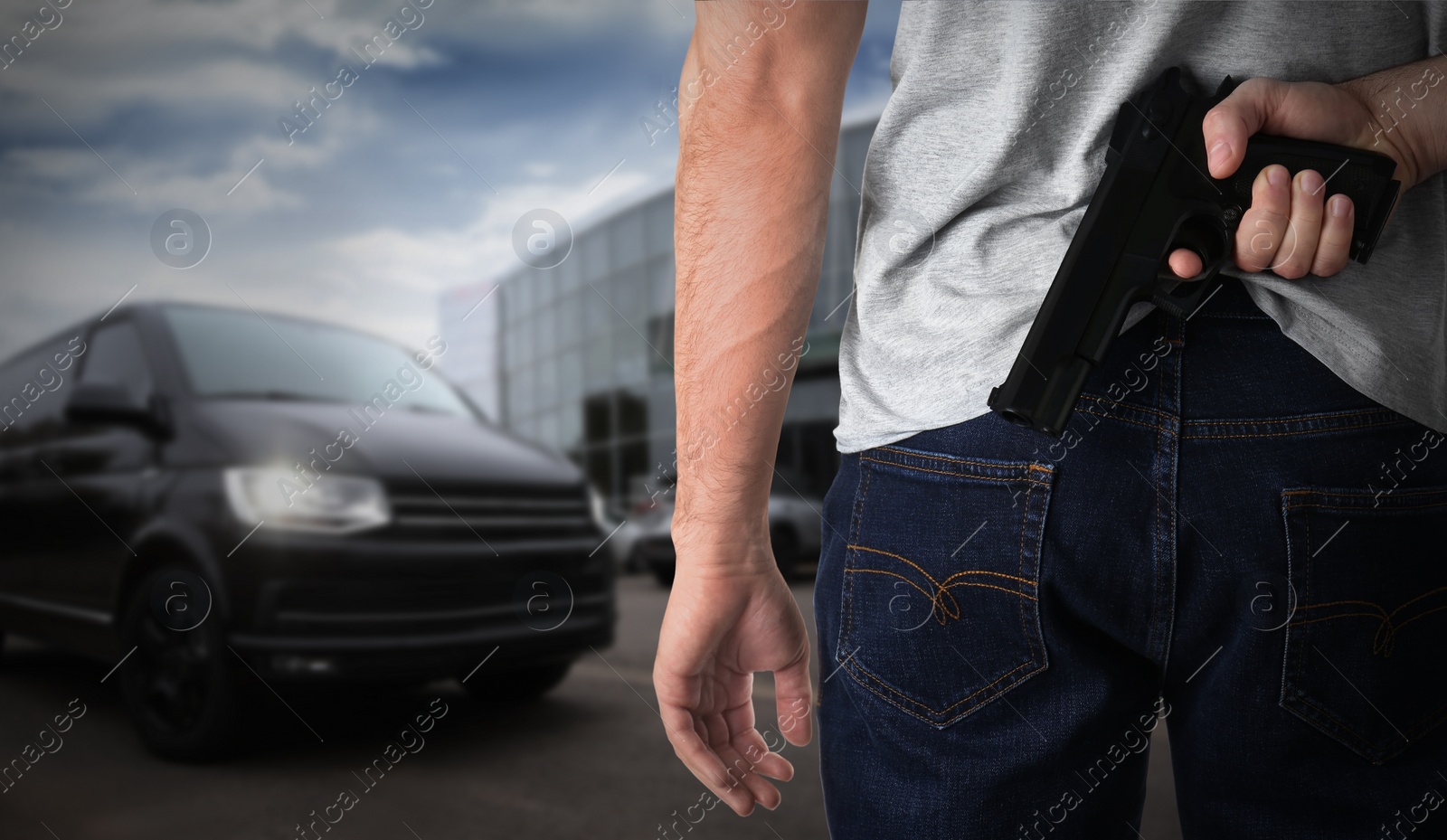 Image of Man with gun near car outdoors, closeup