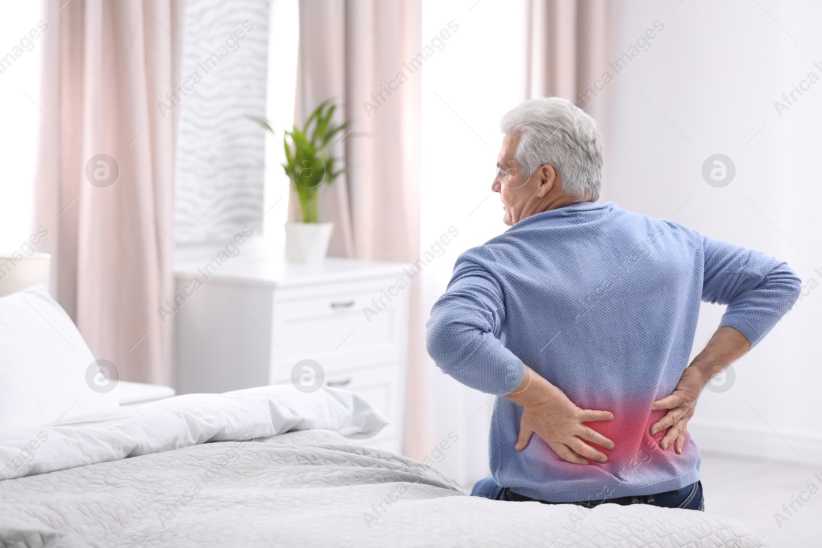 Image of Senior man suffering from pain in lower back on bed at home