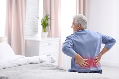 Image of Senior man suffering from pain in lower back on bed at home