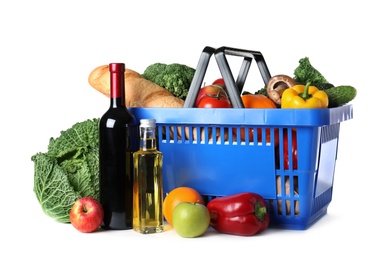 Shopping basket and grocery products on white background