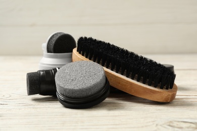 Composition with shoe care accessories on white wooden table closeup