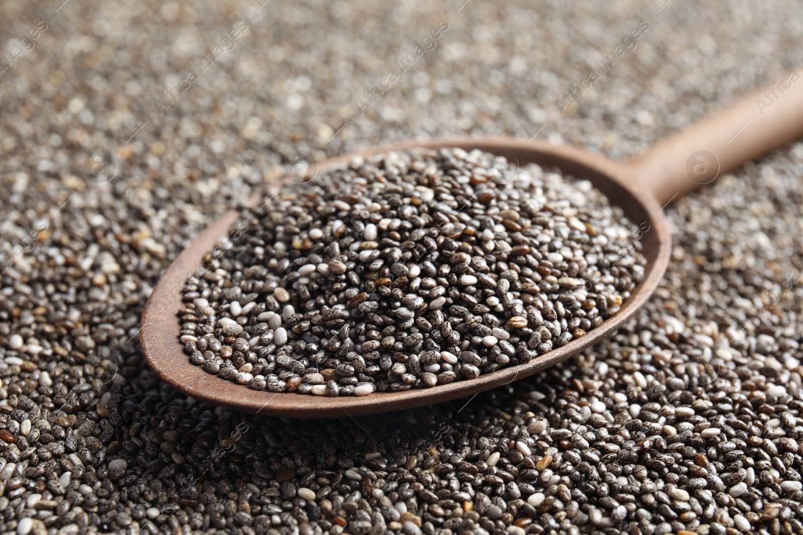 Photo of Spoon of chia seeds on grains, closeup