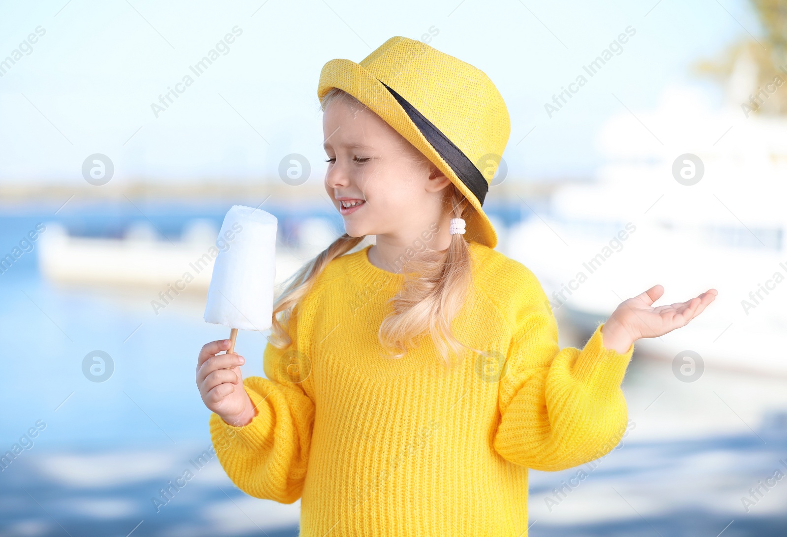 Photo of Cute little girl with cotton candy outdoors