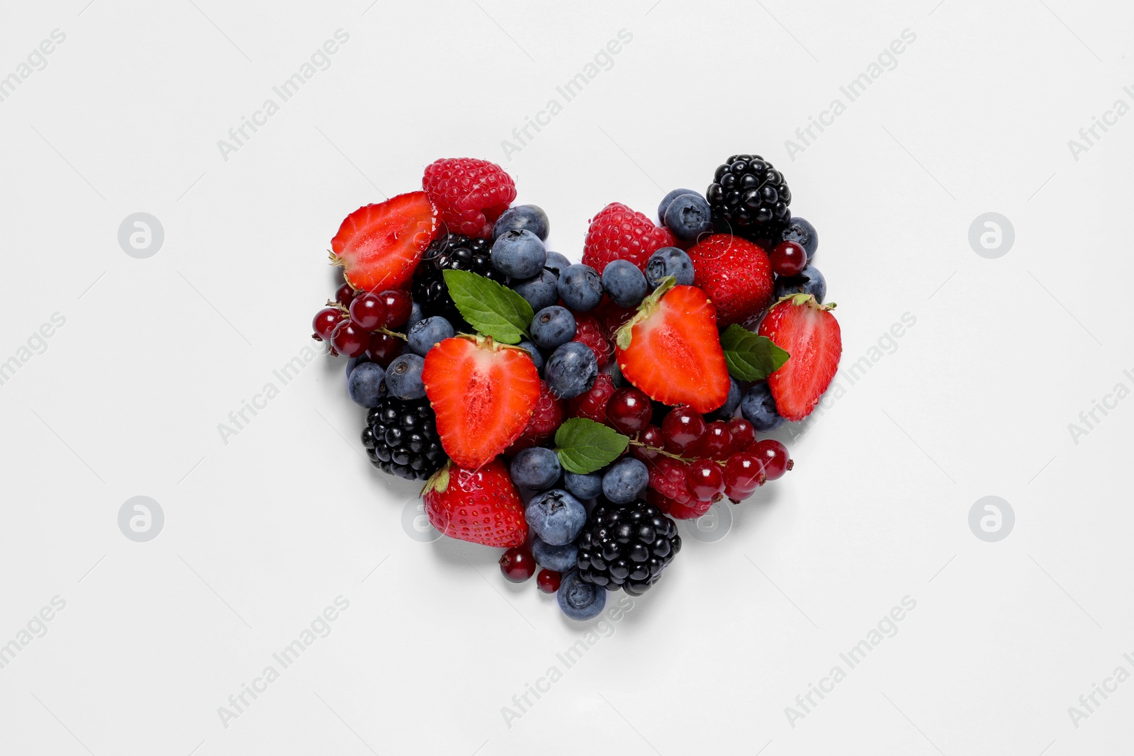 Photo of Heart made of different fresh ripe berries on white table, top view