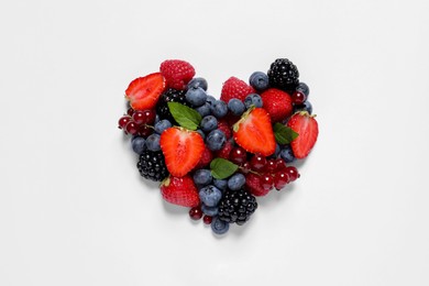 Photo of Heart made of different fresh ripe berries on white table, top view