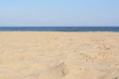 Photo of Blurred view of sandy beach near sea on sunny day
