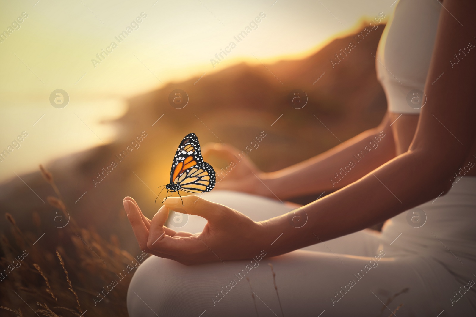 Image of Woman meditating outdoors at sunset, closeup view