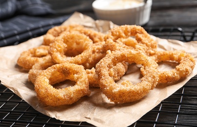 Photo of Cooling rack with homemade crunchy fried onion rings, closeup