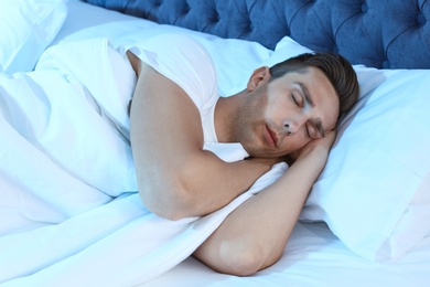 Young man sleeping in bed at night