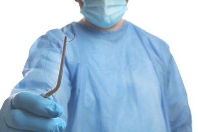 Photo of Doctor holding needle with suture thread on white background, closeup. Medical equipment