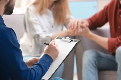 Photo of Family psychologist working with young couple in office, closeup