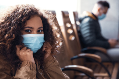 African-American woman with disposable mask indoors. Virus protection