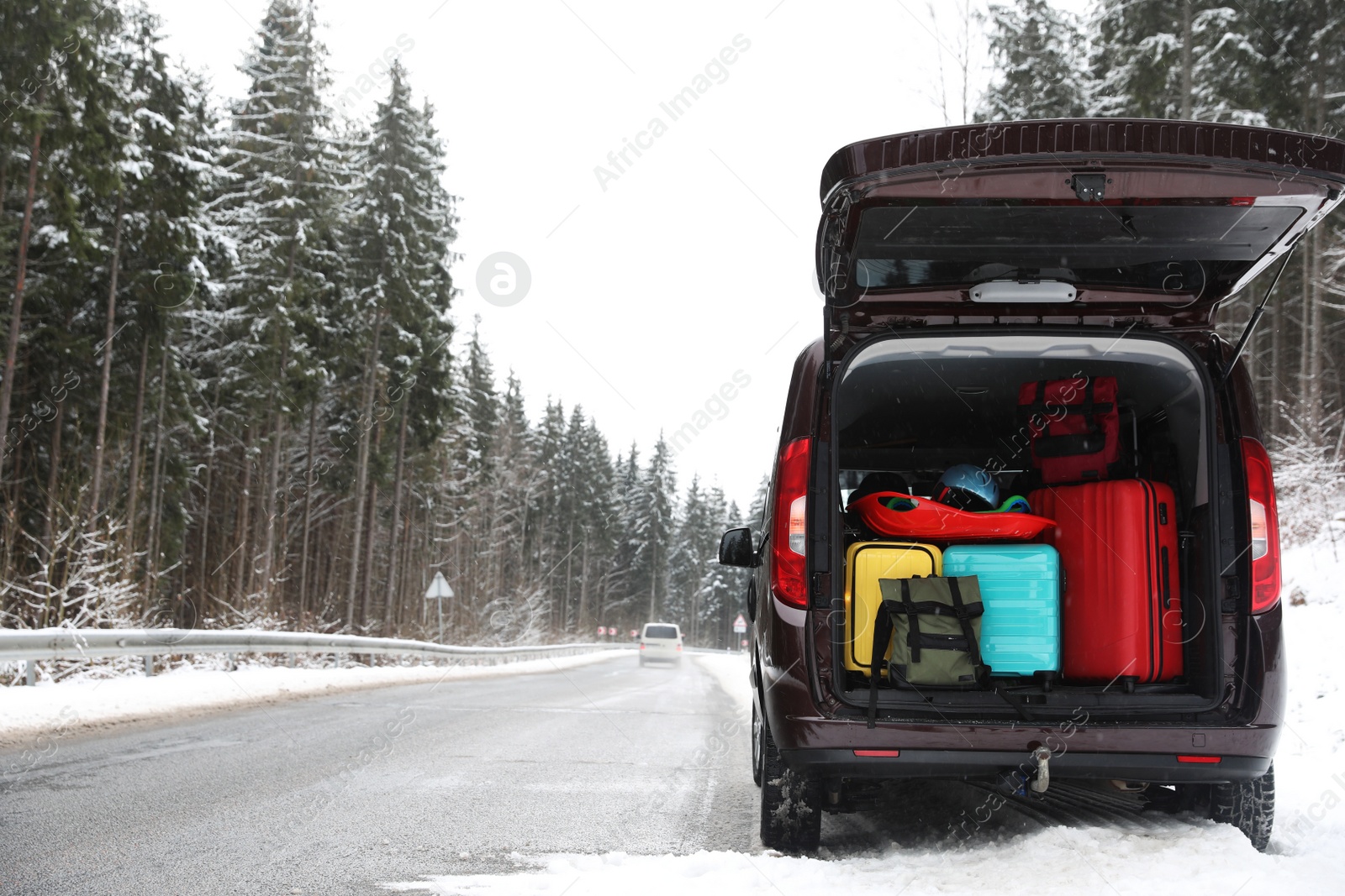 Photo of Car with open trunk full of luggage near road, space for text. Winter vacation